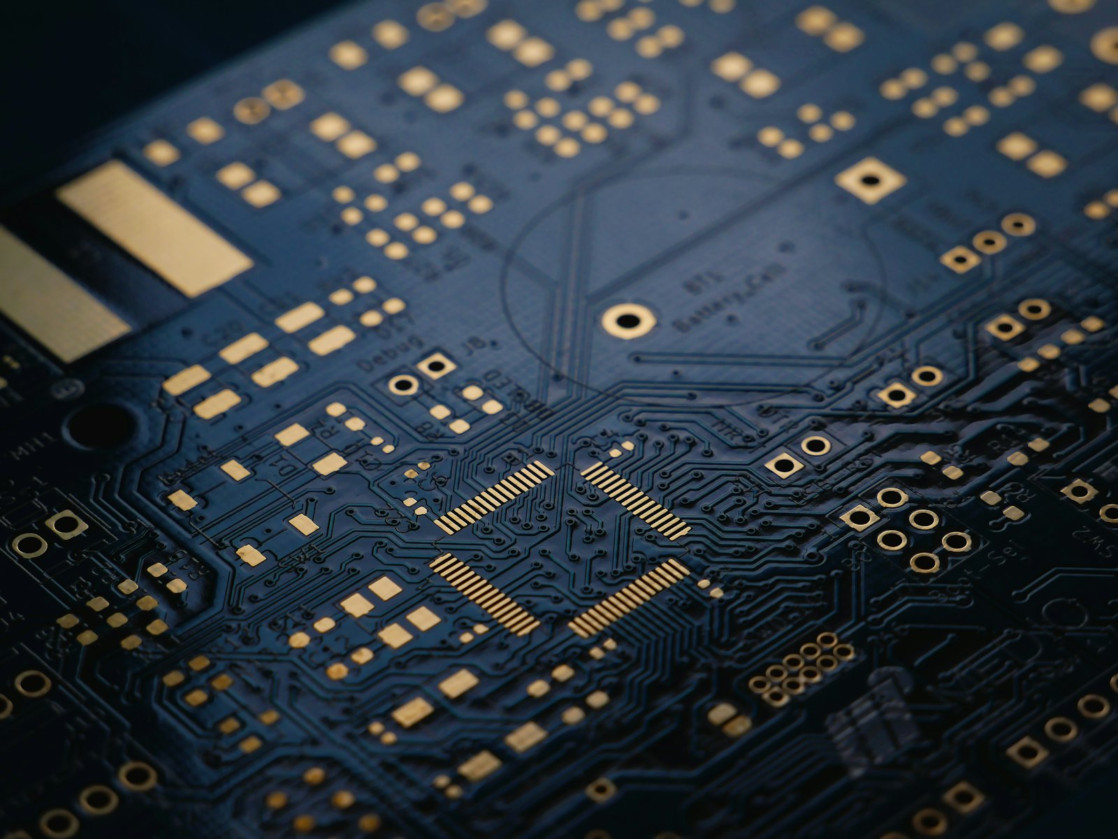 Close-up of a dark circuit board with gold traces — fixed, testable, repeatable logic.